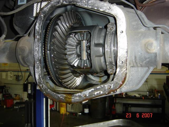 Differential housing with gears and bolts, showing oil residue. Date stamp reads 23 6 2007