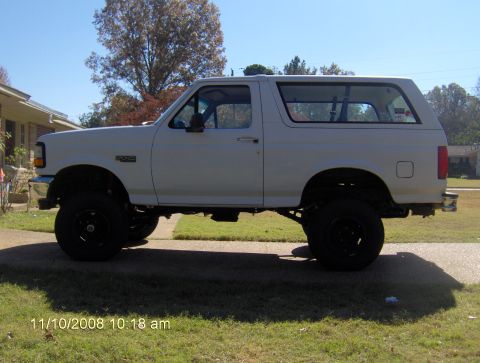 1995 Ford Bronco - This white 1995 Ford Bronco is shown from the side, lifted with black wheels.