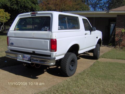 1995 Ford Bronco - Rear view of a white 1995 Ford Bronco with lifted suspension and aftermarket wheels.