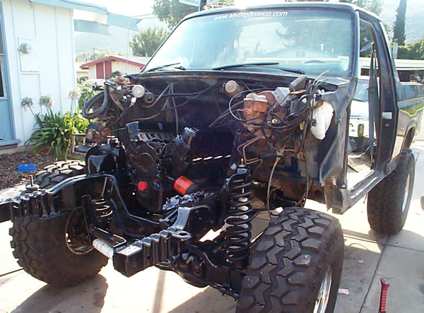 Lifted truck front clip stripped to frame and engine bay with mud tires