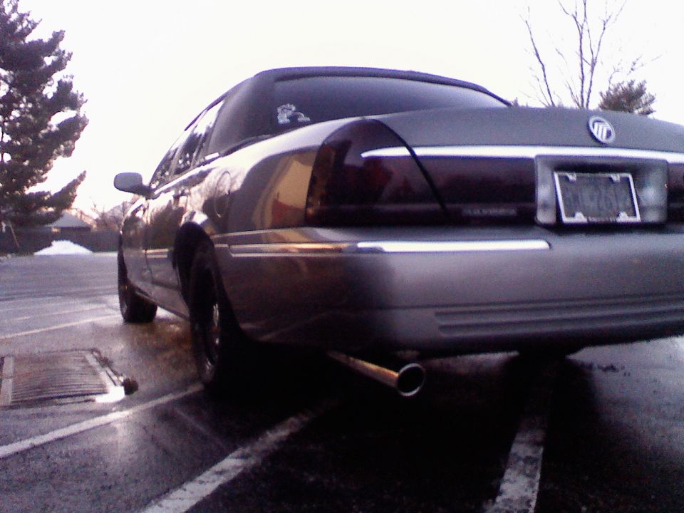 Rear view of a gray Mercury Grand Marquis sedan with dual exhaust