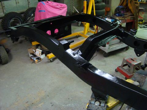 1948 Jeep Wrangler - Vehicle frame undergoing restoration work in a garage setting.