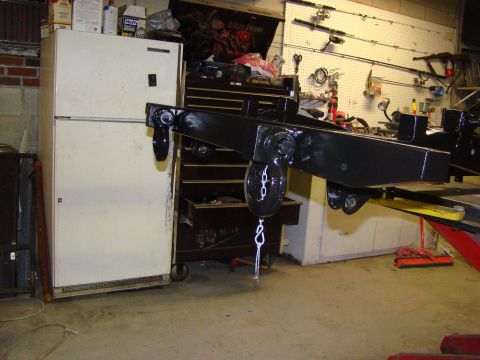 1948 Jeep Wrangler - A black metal frame with a pulley and chain is visible, alongside a refrigerator and tool chest in a garage setting.