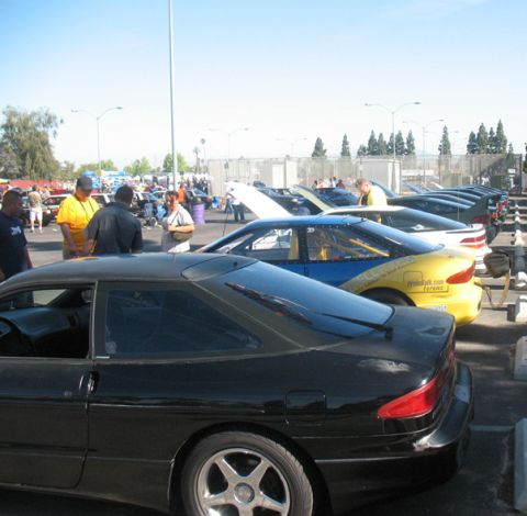 1995 Ford Probe - A black 1995 Ford Probe is parked at an outdoor car show with several other vehicles in the background.
