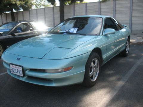 1995 Ford Probe - A light blue 1995 Ford Probe is parked in a lot, with another vehicle visible behind it.