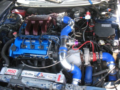 1995 Ford Probe - Customized engine bay a turbocharged Mazda engine with vibrant blue components and polished intercooler piping.