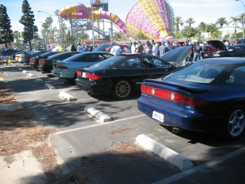 1995 Ford Probe - A line of Ford Probe cars are parked in a lot, with a water park visible in the background.