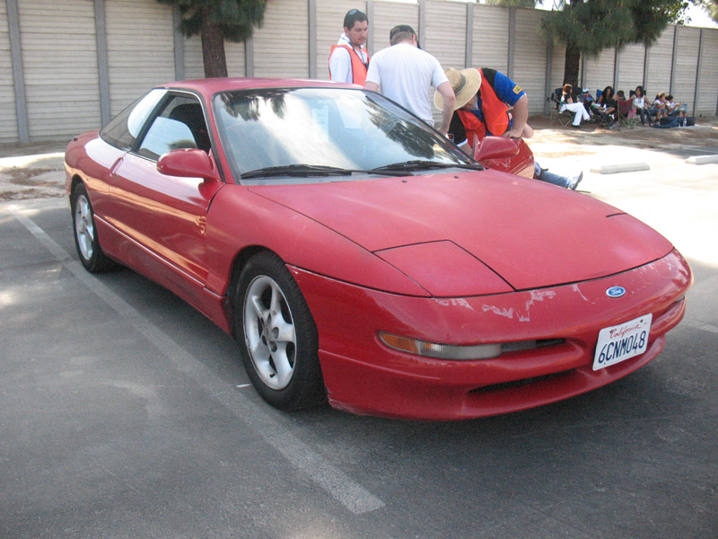 Red Ford Probe coupe front three-quarter view in parking lot with California plate 6CNM048