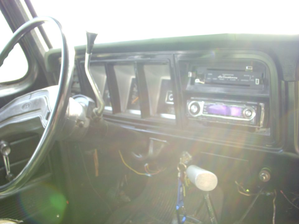 1974 Ford F-350 interior showing steering wheel, dashboard, and aftermarket radio