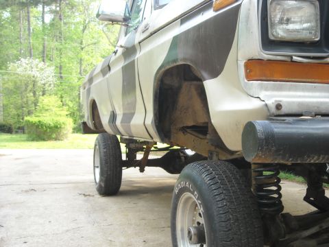 1979 Ford F-150 - This lifted 1979 Ford F-150 pickup truck features a unique camouflage paint scheme and is viewed from the side.