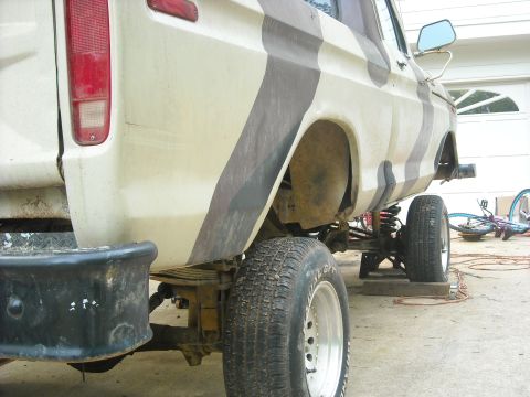 1979 Ford F-150 - Rear view of a 1979 Ford F-150 pickup truck, showing its lifted suspension and camouflage paint job.