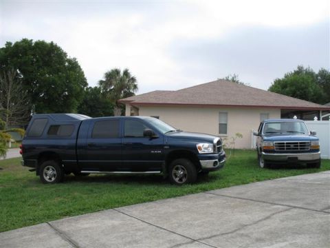 1992 Ford Bronco - A blue Ford pickup truck is parked in a driveway next to a newer Dodge Ram truck.