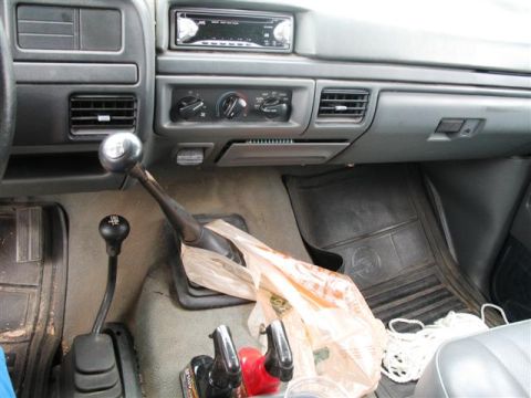1992 Ford Bronco - The interior of a truck features a manual transmission with two gear shifters and an aftermarket stereo.