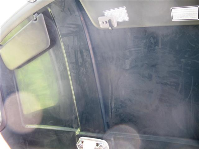 Tinted rear glass and tan headliner with warning labels inside a truck