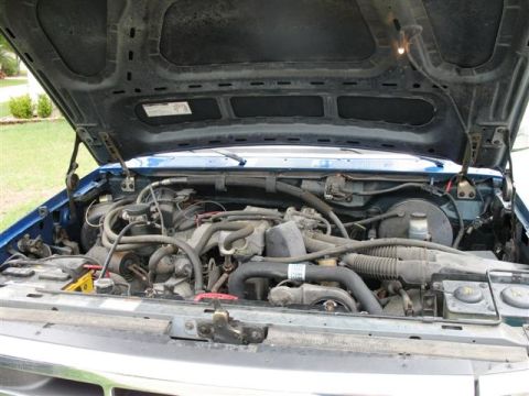 1992 Ford Bronco - The engine bay of a blue 1992 Ford Bronco, viewed from above with the hood raised.