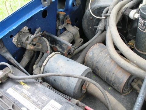 1992 Ford Bronco - Close-up view of engine bay components, including a battery and various hoses and electrical parts.