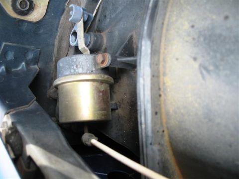 1992 Ford Bronco - Close-up view of a vacuum canister and linkage, likely from an engine compartment.
