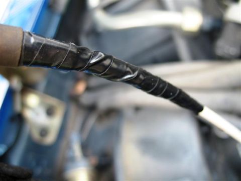1992 Ford Bronco - Close-up of a wire harness repair with black electrical tape.