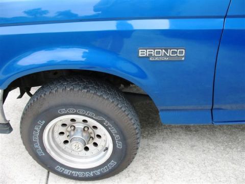 1992 Ford Bronco - Close-up of a blue 1992 Ford Bronco Custom's front fender and wheel.