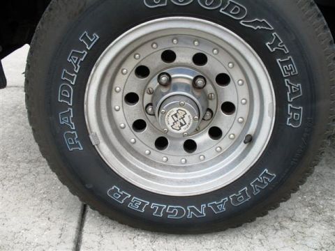1992 Ford Bronco - A close-up view of a tire and wheel assembly, showing brand markings and rim details.