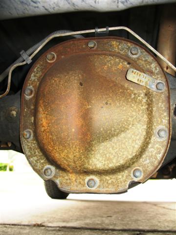 1992 Ford Bronco - Close-up of a rusty rear differential cover with a visible identification tag.