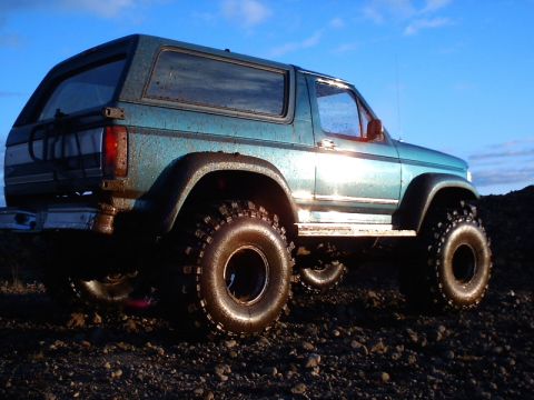 1996 Ford Bronco - This modified SUV features large off-road tires and appears to be from the 1980s.