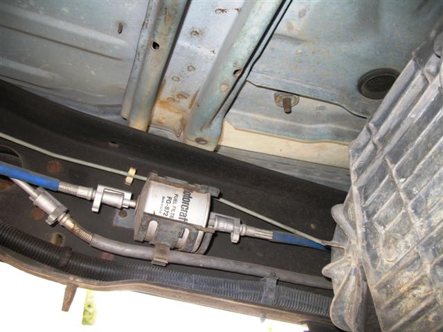 Motorcraft FG-872 fuel filter mounted on a vehicle frame with blue fuel lines.