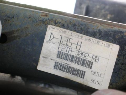 1992 Ford Bronco - A close-up of a white sticker with black text and a barcode is affixed to a rusty metal surface. The sticker contains part numbers and a da…