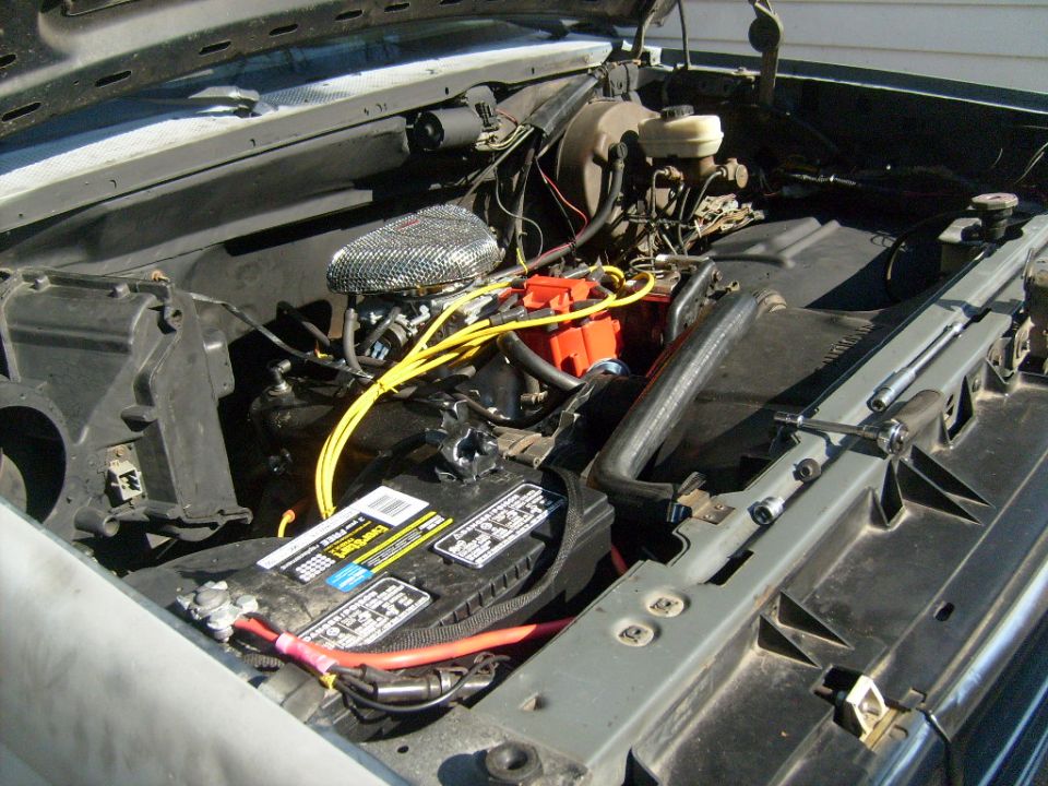 Ford V8 engine bay with chrome air cleaner, yellow plug wires, and Energizer battery