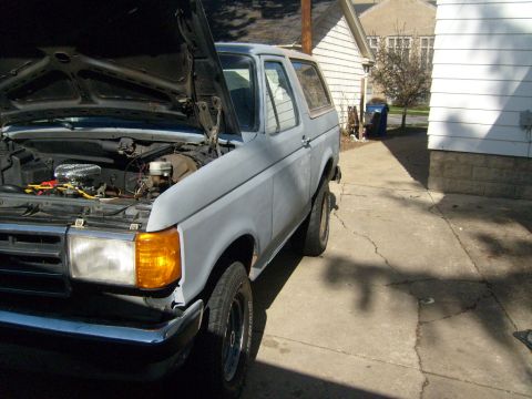 1987 Ford Bronco - This 1987 Ford Bronco is shown in a 3/4 front view with its hood open, revealing the engine compartment.