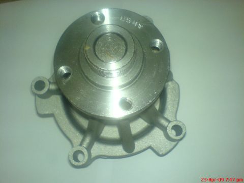 1992 Ford Crown Victoria - A silver metal water pump impeller with the text "USMW" visible on the top surface. The pump housing has four mounting holes and a distinct…