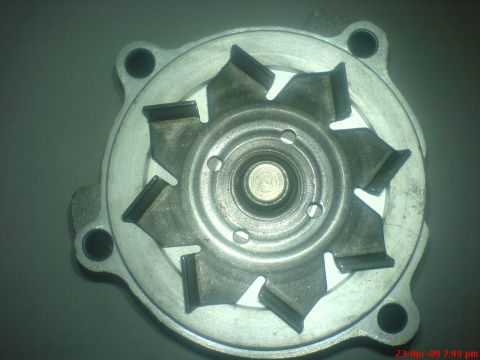1992 Ford Crown Victoria - A close-up, top-down view of a metal impeller with eight angled blades. The impeller is mounted on a circular metal housing with four bolt…
