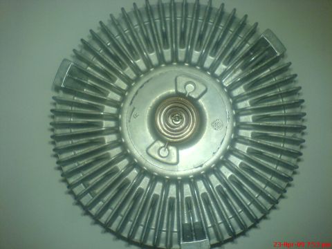1992 Ford Crown Victoria - A close-up, overhead view of a metal fan clutch, likely for a vehicle's cooling system. The part is silver and features numerous fins radia…