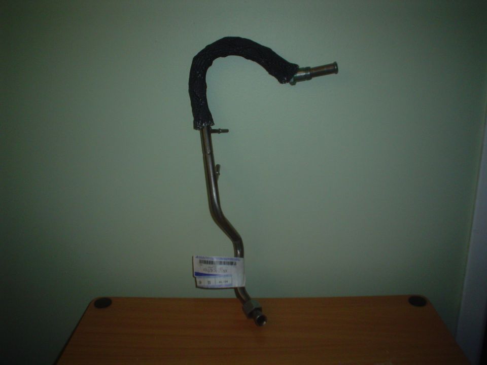 Metal fuel line with black braided hose cover and white label.