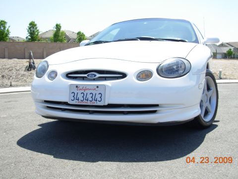 1995 Ford Taurus - Front view of a white 1995 Ford Taurus parked on a sunny day.