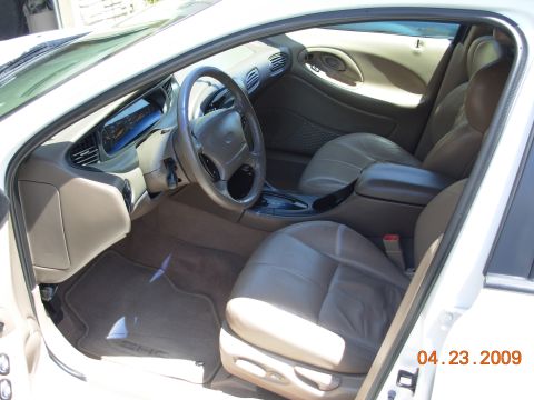 1995 Ford Taurus - The interior of a car is shown, leather seats and the dashboard.