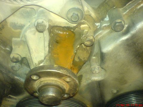 1992 Ford Crown Victoria - Close-up of a corroded engine water pump housing, showing rust and residue.