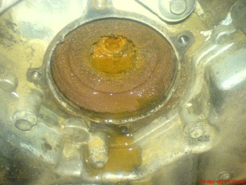 1992 Ford Crown Victoria - The heavily corroded water pump housing shows signs of significant rust and leakage.