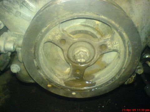 1992 Ford Crown Victoria - A close-up view of a vehicle's crankshaft pulley, showing signs of wear and fluid leakage.