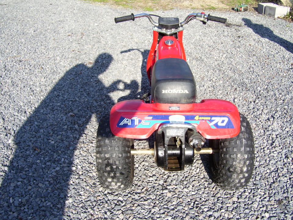 Red Honda ATC 70 three-wheeler, rear view on gravel with 'ATC 70 4-Speed' fender decal