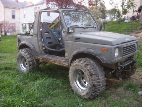 1987 Suzuki Samurai - This modified Suzuki Samurai features large off-road tires and racing seats, suggesting it's built for terrain.