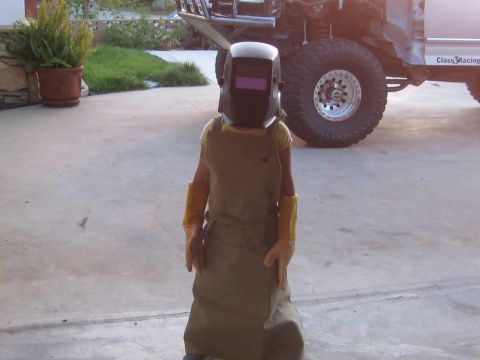 1996 Ford Bronco - Person in welding gear stands before a modified off-road vehicle with a "Class3Racing" decal visible.
