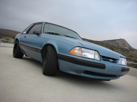 1990 Ford Mustang - Front 3/4 view of a blue 1990 Ford Mustang with black wheels.