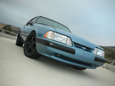 1990 Ford Mustang - Front view of a blue 1990 Ford Mustang with aftermarket black wheels.