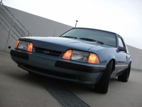 1990 Ford Mustang - Front view of a blue 1990 Ford Mustang parked on a concrete surface.