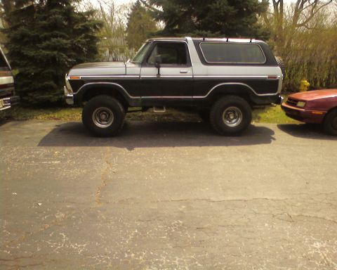 1979 Ford Bronco - A two-tone black and silver Ford Bronco is parked next to another vehicle.