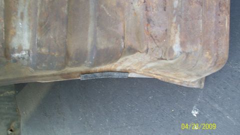 1972 Ford Ranchero - Close-up of a heavily rusted metal part, possibly a fuel tank or similar component.