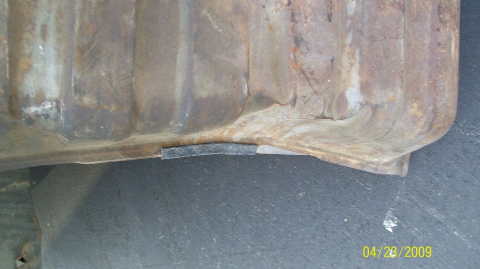 rusted metal object with ribbed texture and a black strip attached