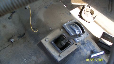 1972 Ford Ranchero - The interior of a vehicle shows a shifter mechanism on the center console, with a yellow wire visible on the dusty floor.