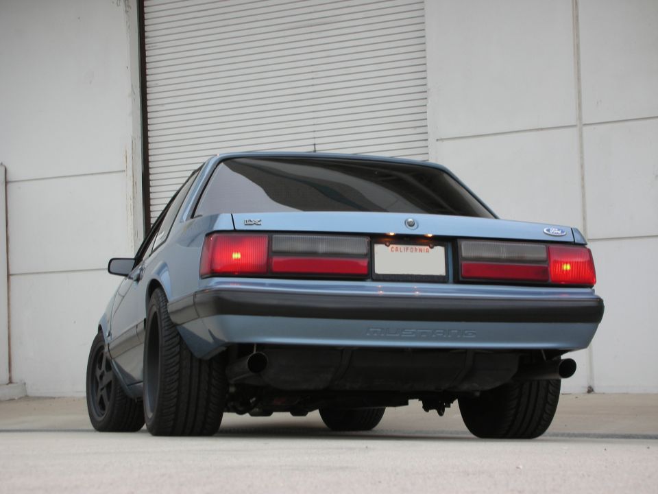 Blue Ford Mustang rear view, California license plate, aftermarket exhaust